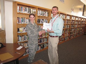 1st Lt. Heather Flynn, USAF, chapter vice president for Young AFCEANs, presents a science teacher grant to Nick Enns of Santa Maria High School at the December meeting. 